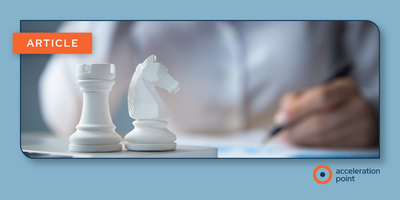 Two white chess pieces -- a rook and a knight -- stand on a surface in the foreground while a person writes in the background, against a soft blue backdrop. The image represents strategic planning and coordinated decision-making in KOL engagement for co-c