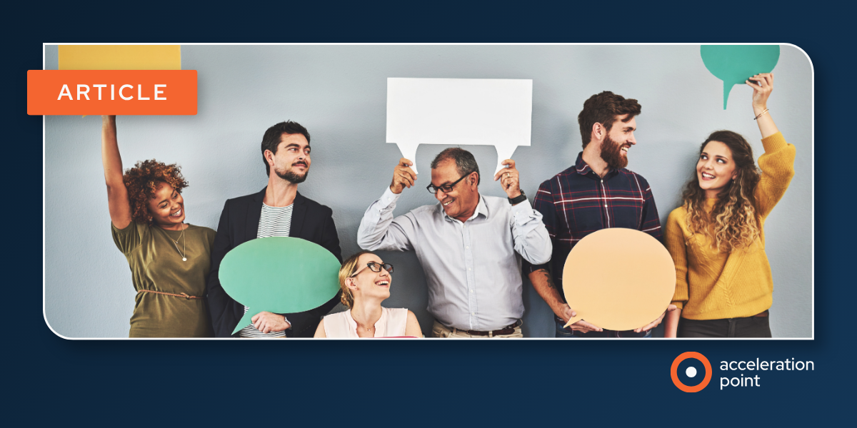 A diverse group of six professionals standing together and cheerfully holding oversized speech bubble props in various colors against a neutral background, tagged as an Acceleration Point article. The image represents the concept of multiple voices contri